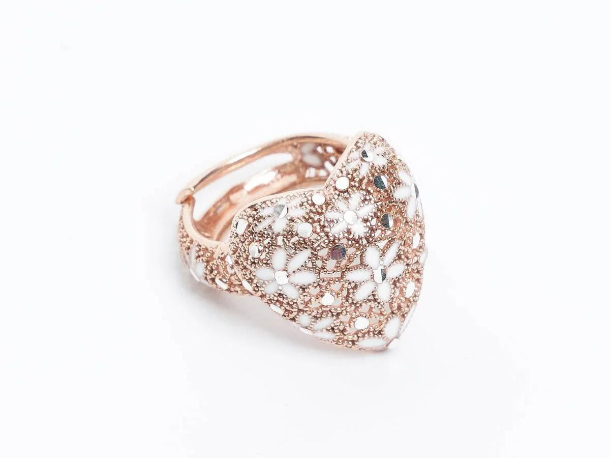 rose gold heart-shaped ring with intricate white floral enamel and bead detailing