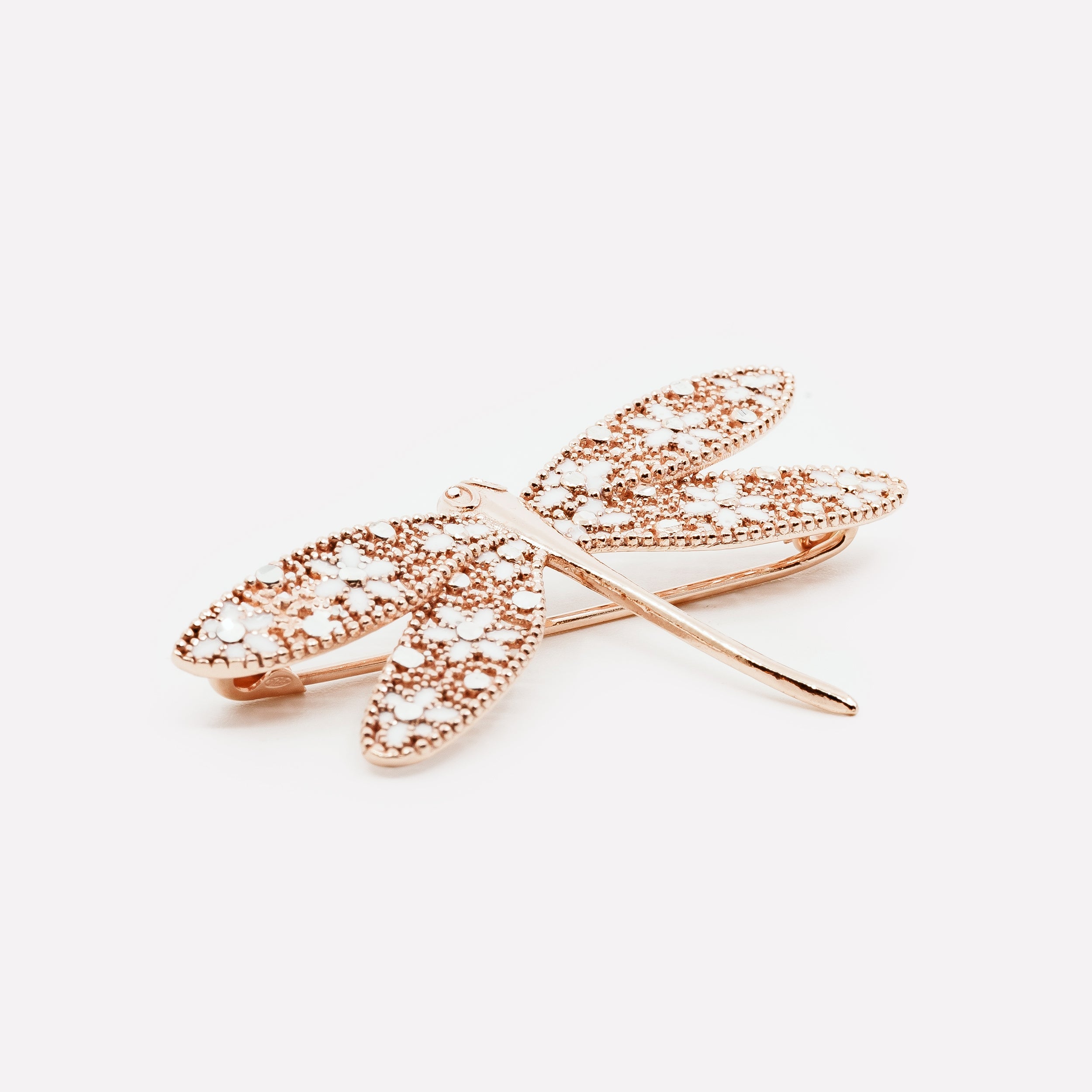 Gold dragonfly brooch with floral cutout wings and embedded rhinestones on white background