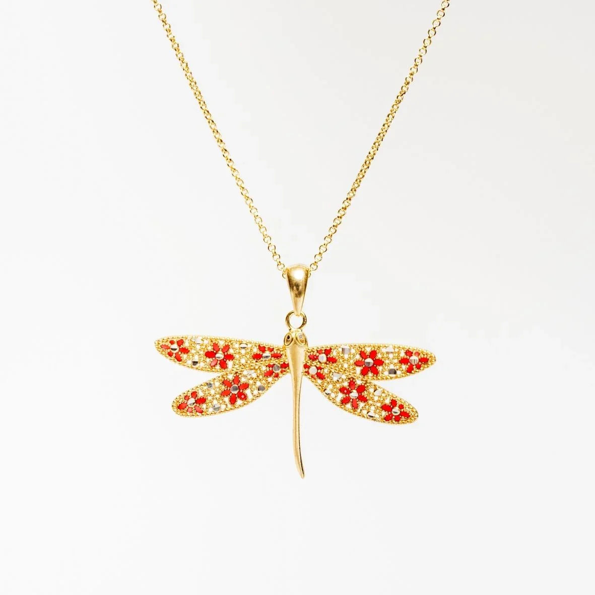 Gold dragonfly pendant necklace with red flower and rhinestone details on white background