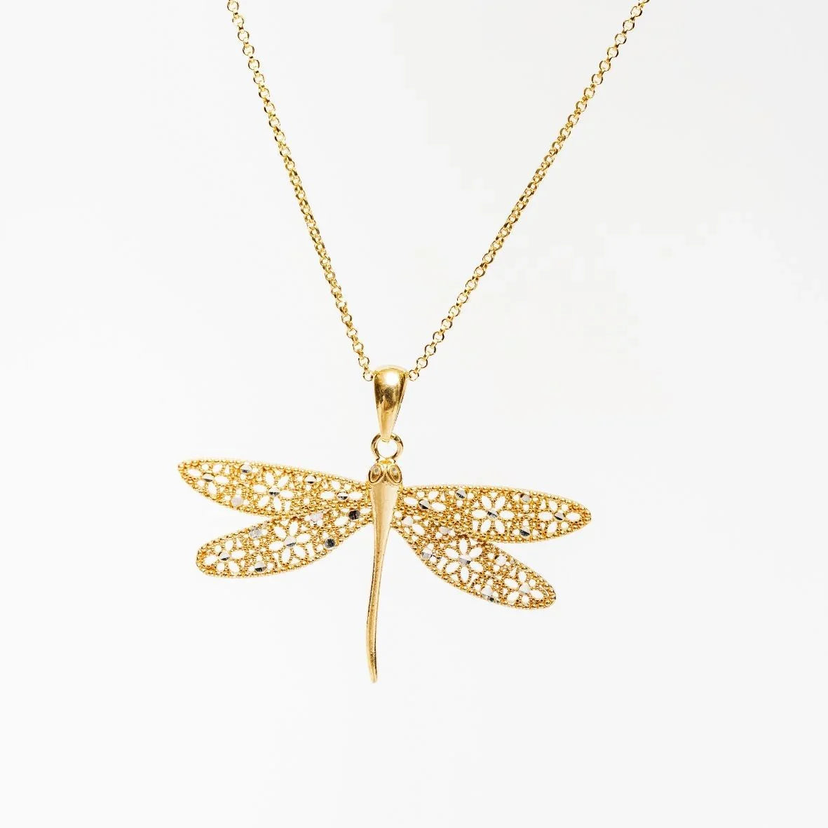 Gold dragonfly pendant necklace with intricate floral filigree wings on white background