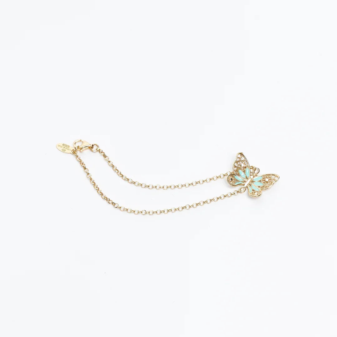 Delicate gold chain bracelet with turquoise and gold butterfly charm on white background
