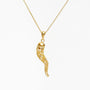 Delicate gold filigree horn pendant necklace with small embedded gemstones on chain