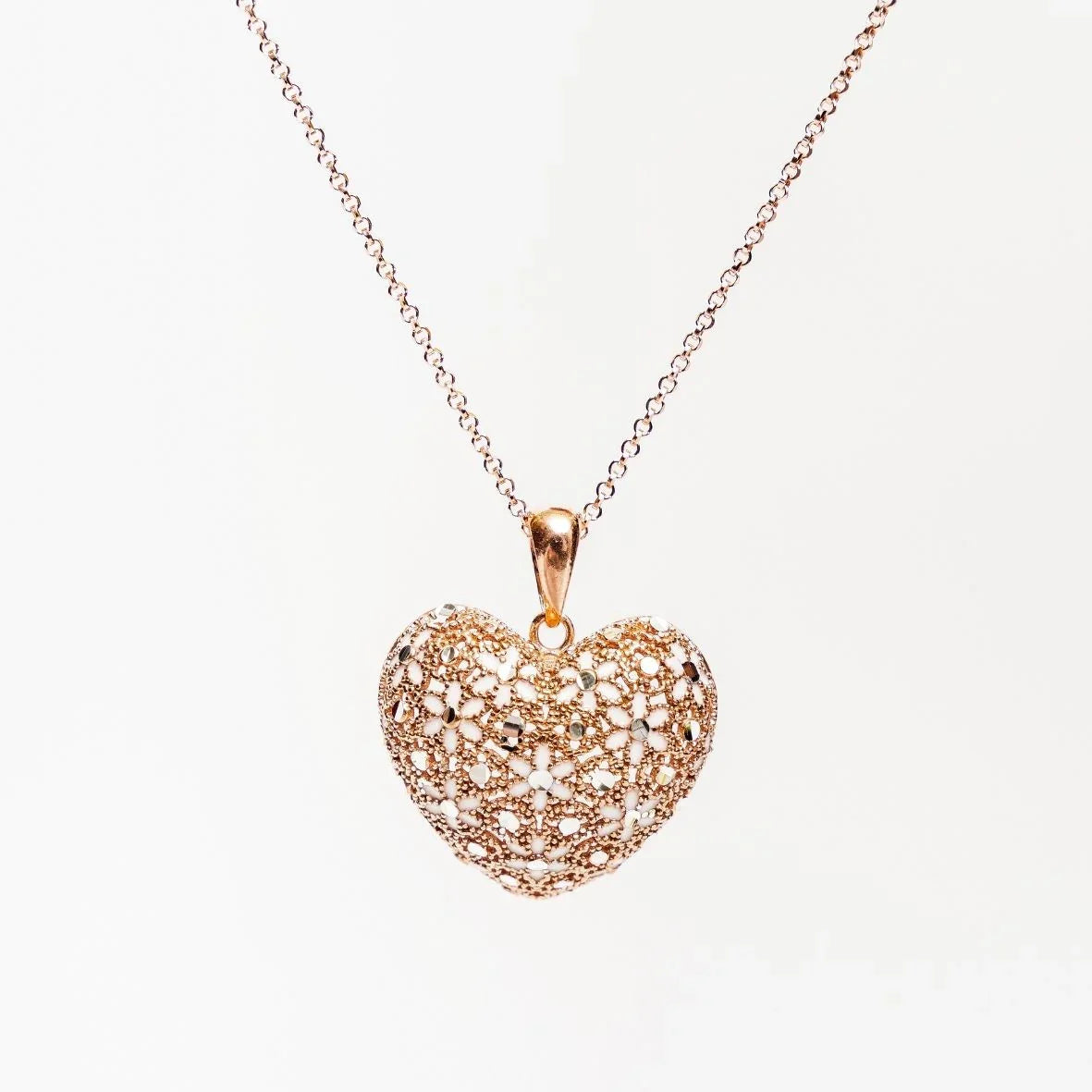 Gold filigree heart pendant necklace on delicate chain with intricate openwork design