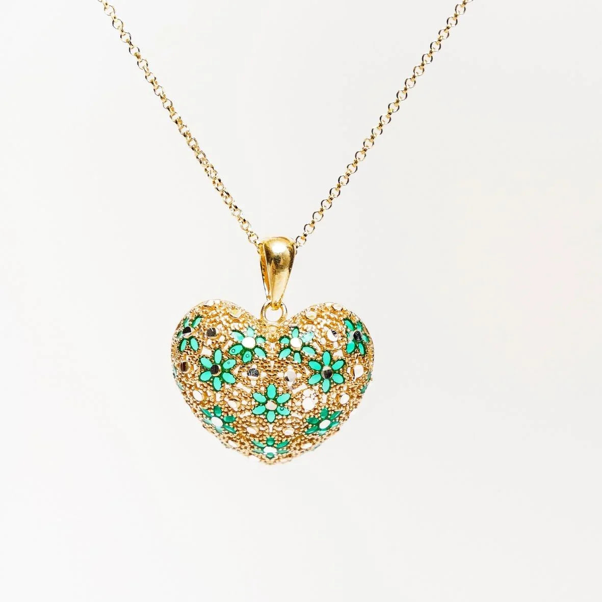 Gold heart pendant necklace with intricate green floral enamel design on white background