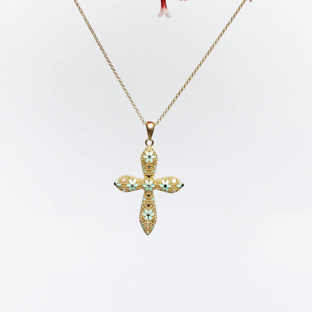 Gold cross pendant necklace with turquoise and dark stone floral accents on white background