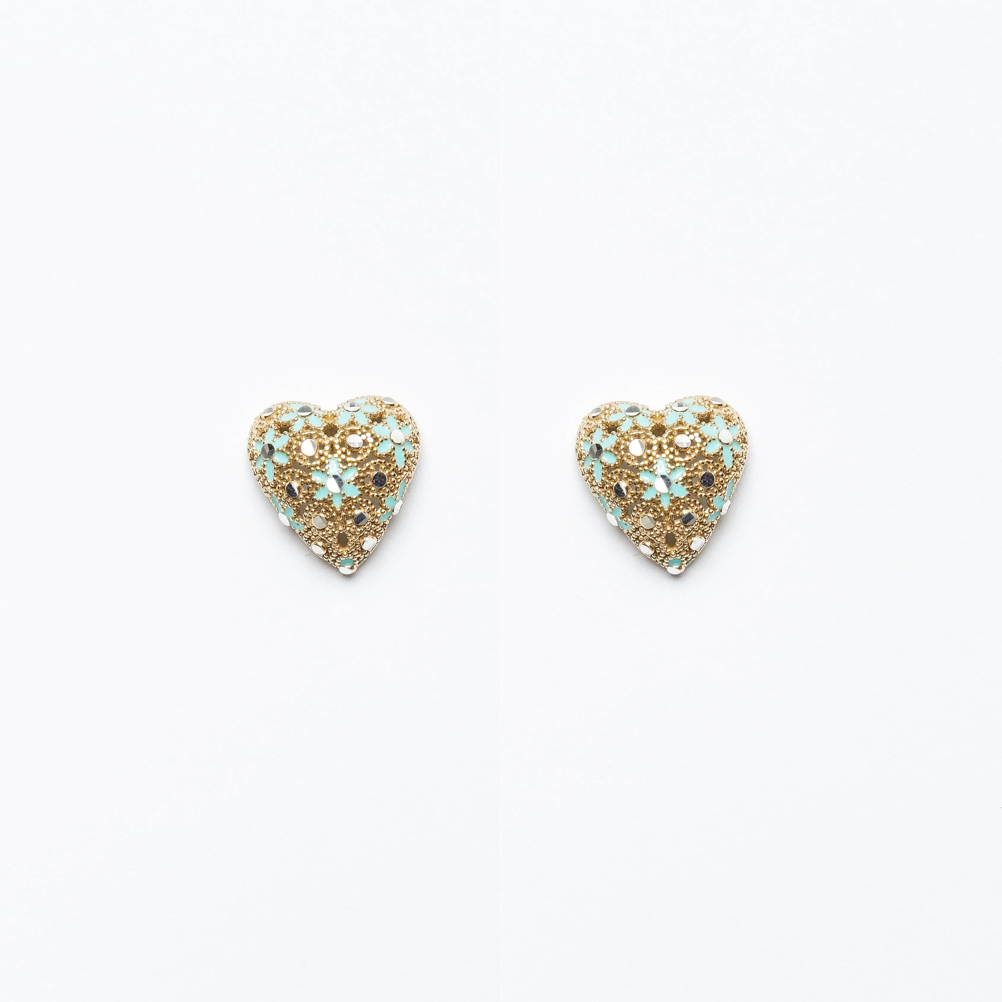 Pair of gold filigree heart-shaped earrings with blue and white floral accents on white background