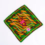 Colorful silk scarf with green camouflage, orange tiger stripes, and central giraffe graphic with 'CHIC' text