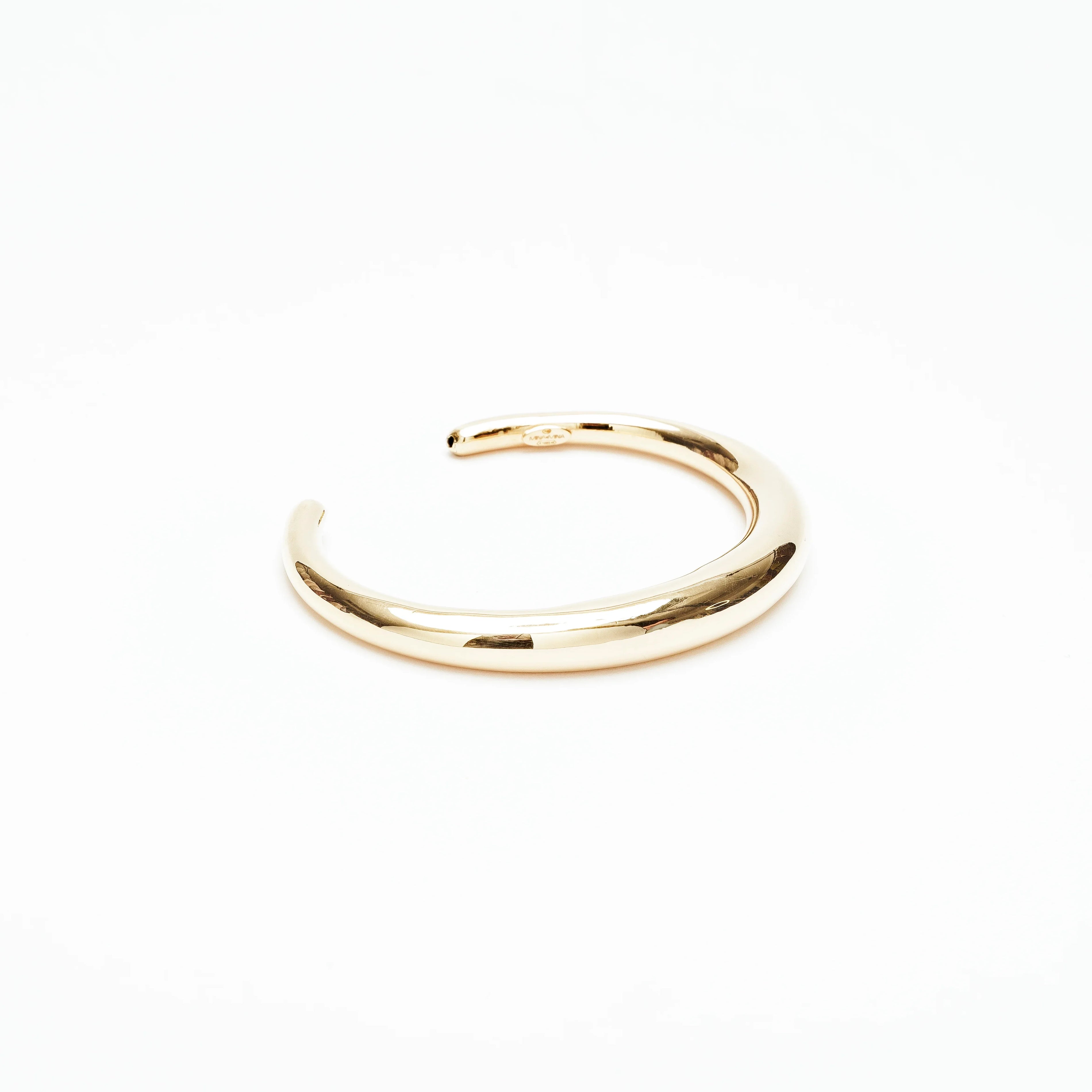 Minimalist polished solid gold cuff bracelet on white background