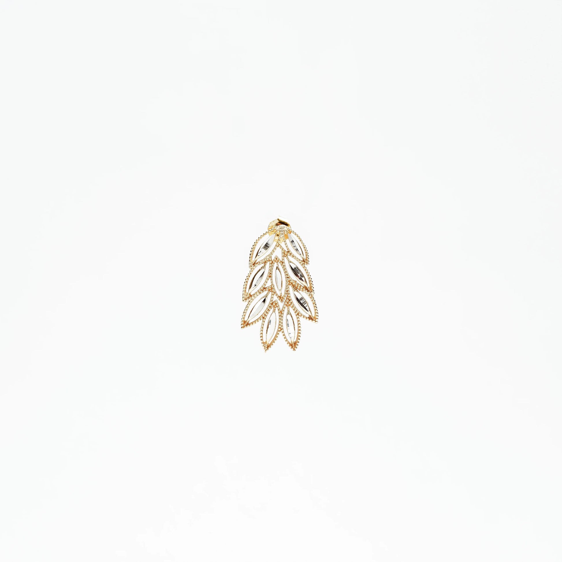 Gold and silver leaf-shaped pendant with intricate design on white background