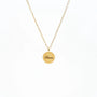 Gold chain necklace with round pendant engraved 'Bloom' on white background
