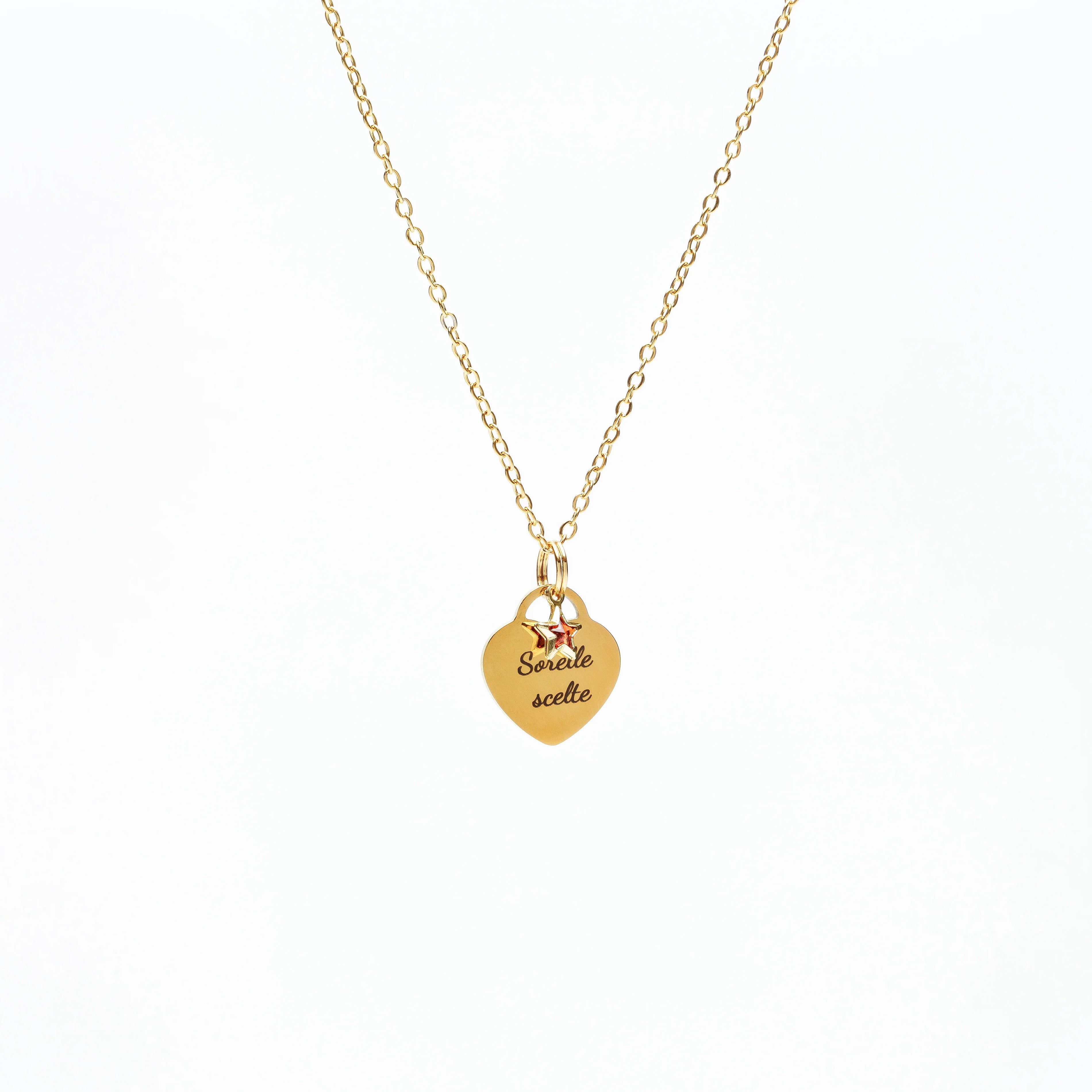 Gold heart pendant necklace with engraved text "Sorelle scelte" and two small star charms