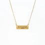 Gold chain necklace with rectangular pendant engraved in Italian on white background