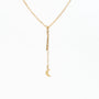 Delicate gold chain necklace with small crescent moon pendant on white background