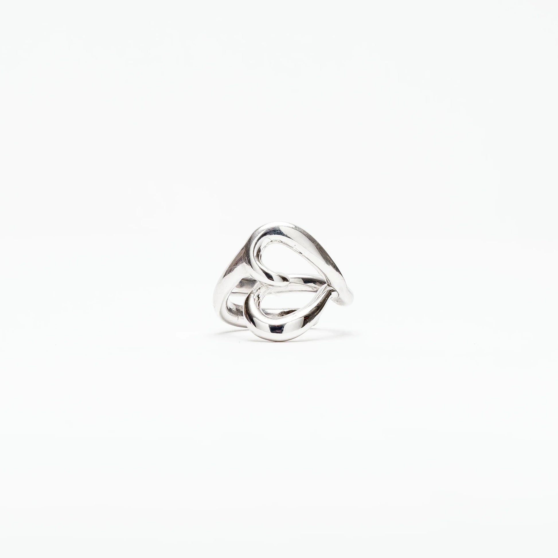 Modern silver ring with an abstract twisted loop design on white background