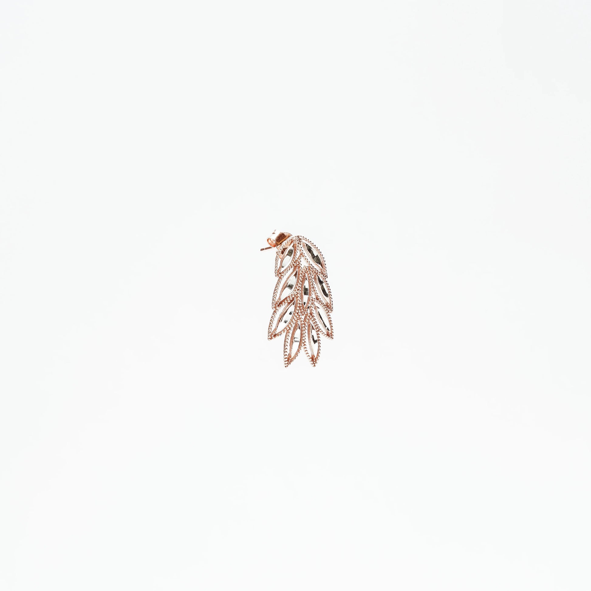 Rose gold leaf-shaped dangling earring with intricate cutout design on white background