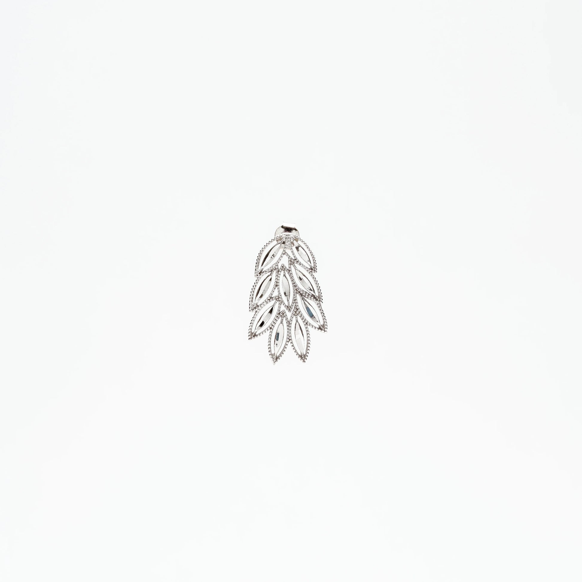 Silver leaf-shaped pendant with intricate openwork and small crystals on white background