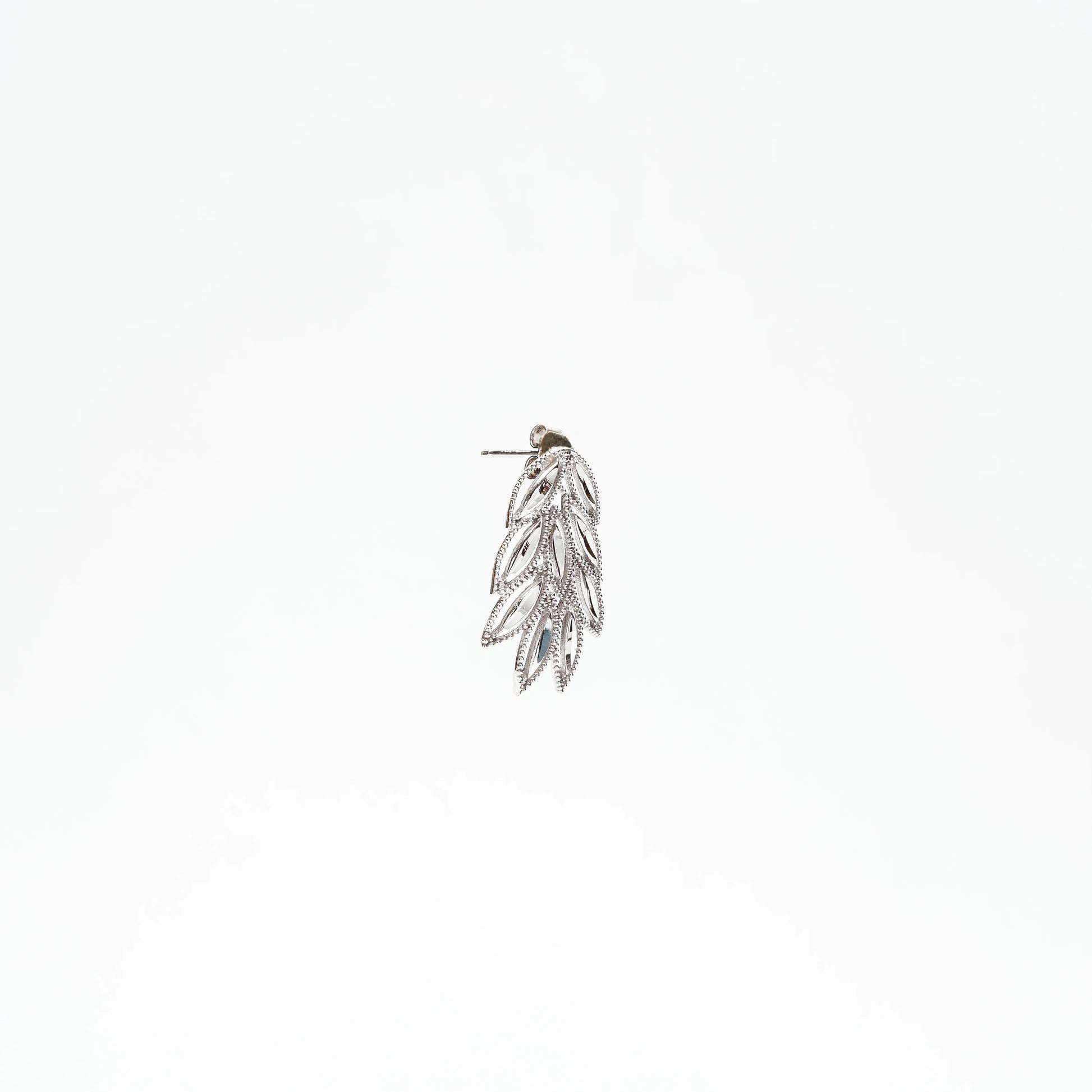 Silver leaf-shaped dangle earring with intricate vintage design on white background
