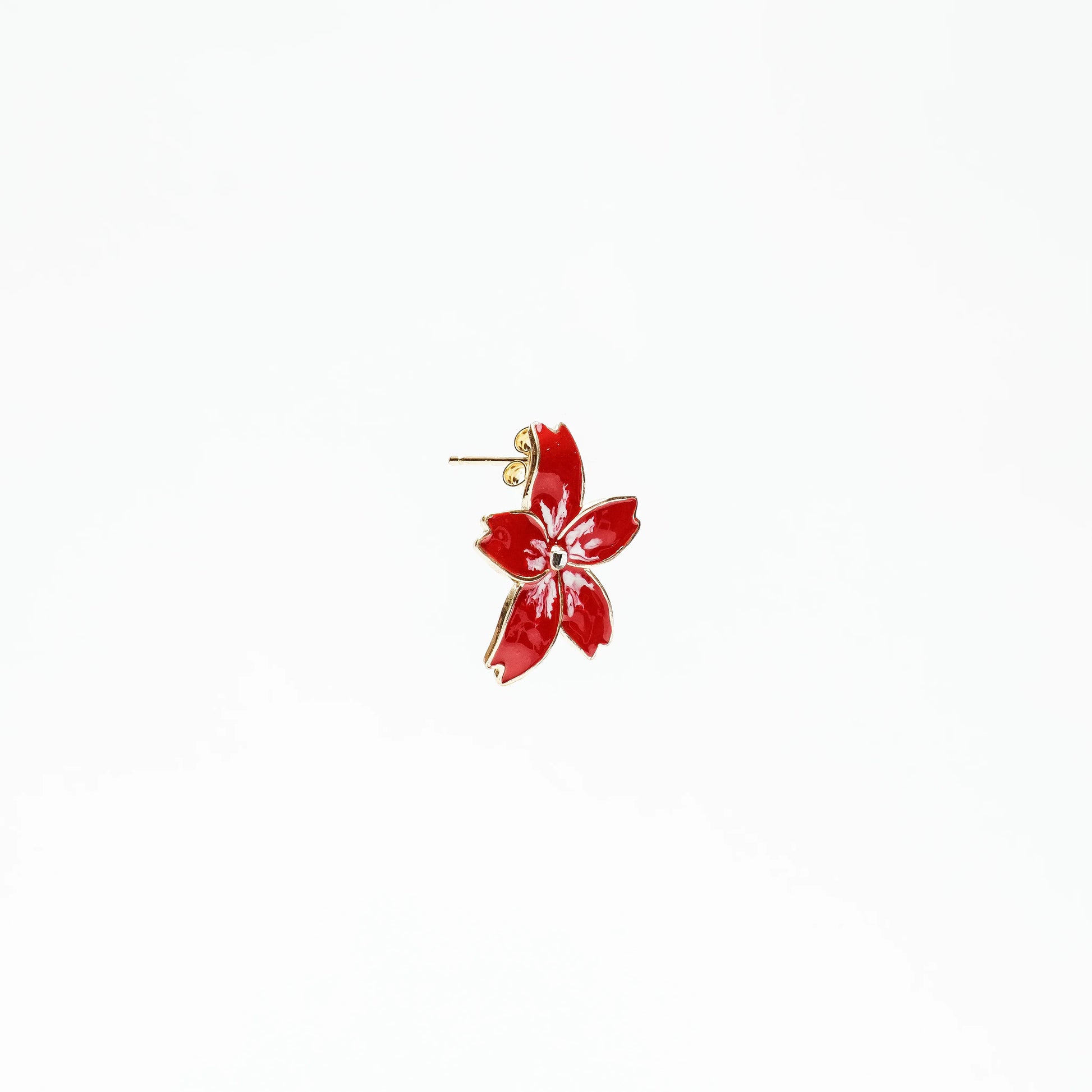 Red flower-shaped enamel stud earring with gold edges on white background